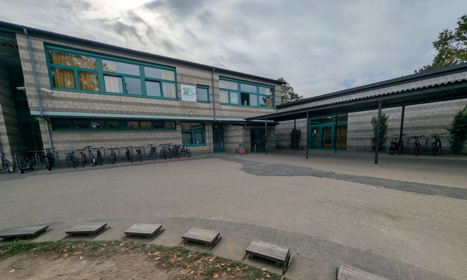 Schulgebäude der Theodor-Heuss-Realschule mit Schulhof und Fahrradständern