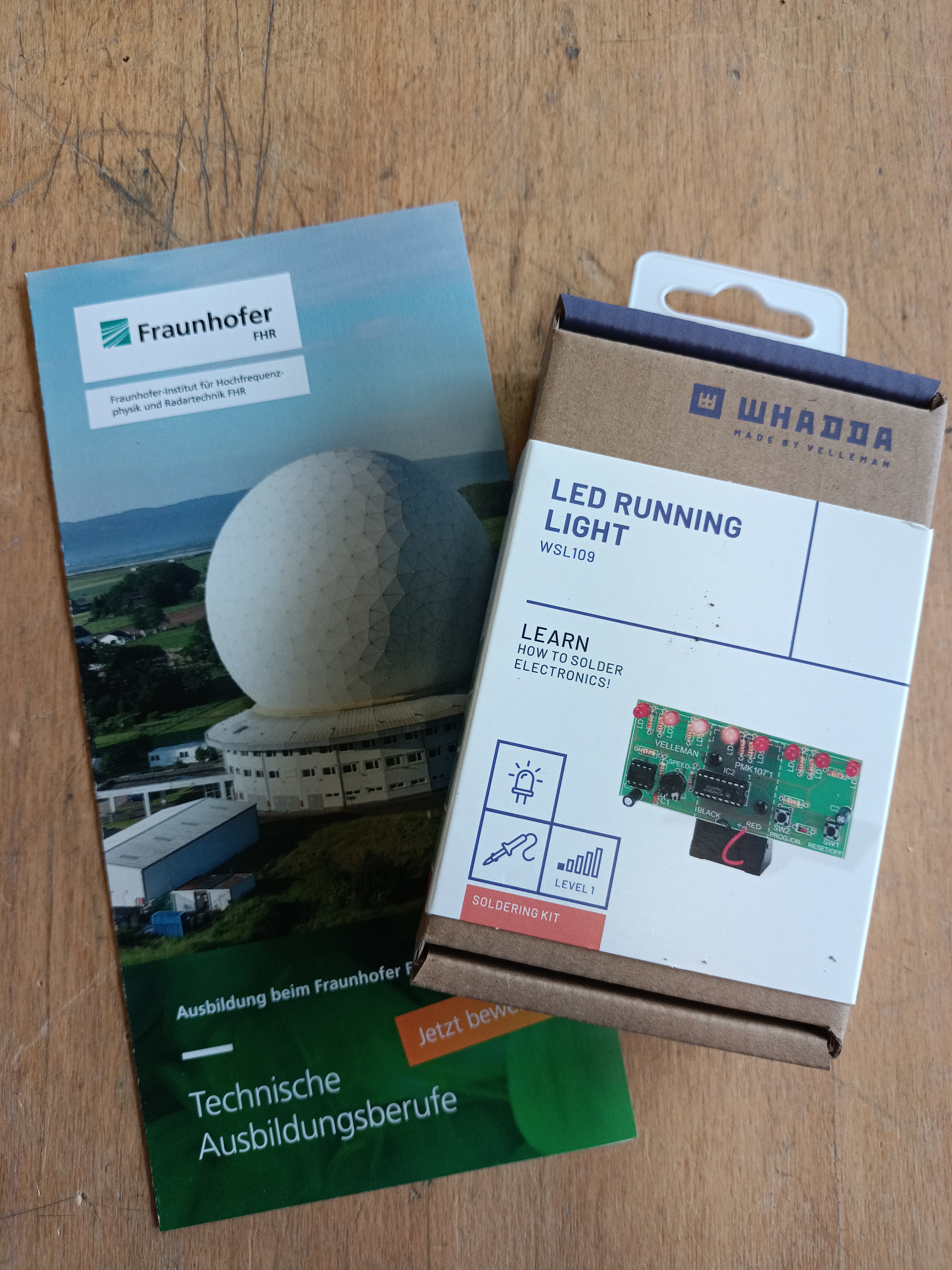 Schüler lötet elektronische Bauteile auf eine grüne Platine, Werkstatt-Angebot mit externen Fachleuten zu Besuch.